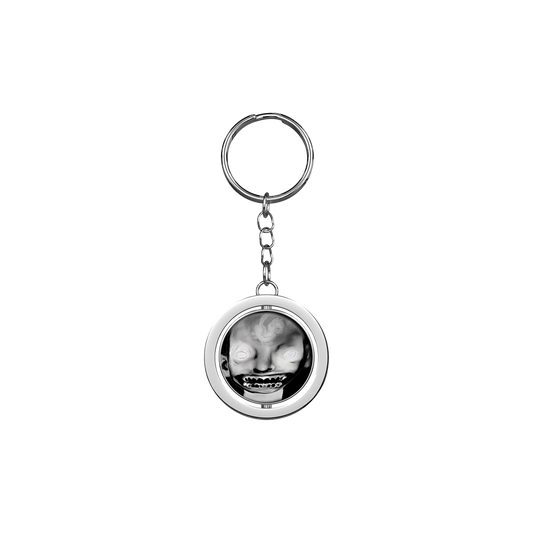 A keyring with a circular charm featuring a black and white image of a person's face