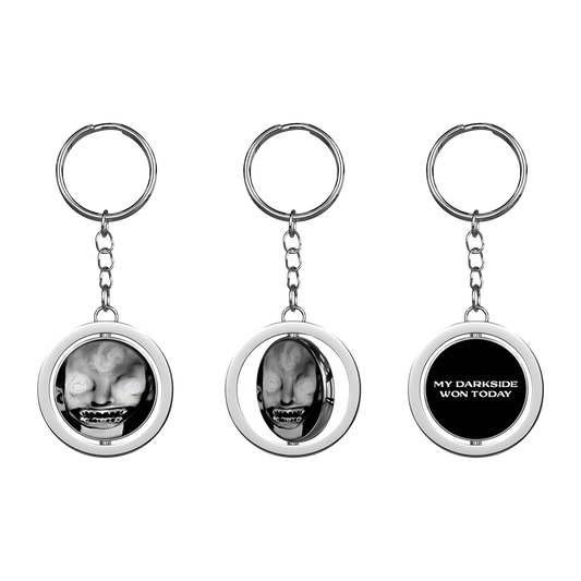 A keyring with a circular charm featuring a black and white image of a person's face