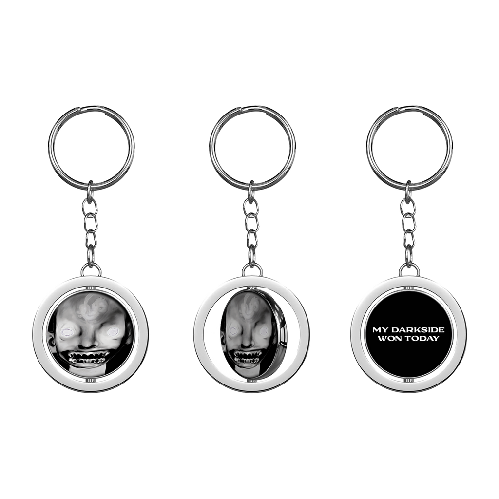 A keyring with a circular charm featuring a black and white image of a person's face