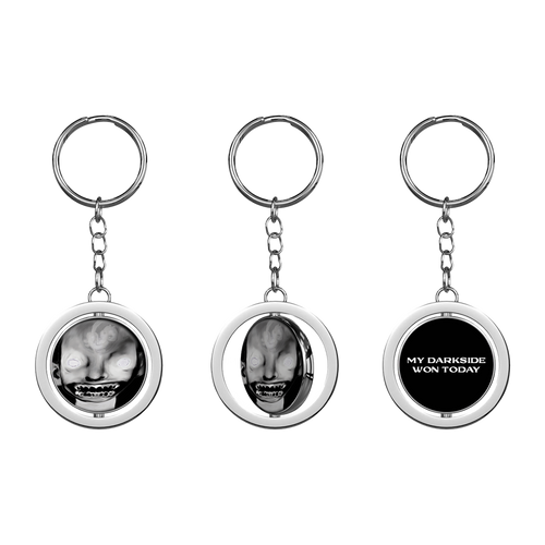 A keyring with a circular charm featuring a black and white image of a person's face